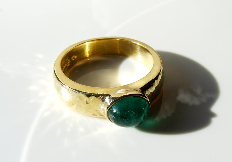 Heavy gold hammered ring with columbian emerald