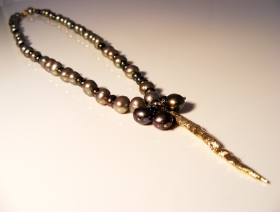 Natural dark freshwater pearls, with solid gold, flowing lava pendant.