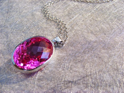huge, bold, facetted fushia pink topaz, oval shape, set in silver with silver chain. 